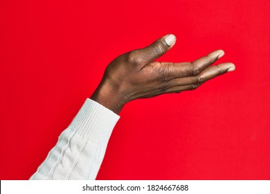 Arm And Hand Of African American Black Young Man Over Red Isolated Background Presenting With Open Palm, Reaching For Support And Help, Assistance Gesture 