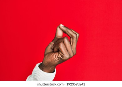 Arm and hand of african american black young man over red isolated background snapping fingers for success, easy and click symbol gesture with hand 