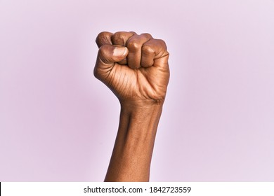 Arm And Hand Of Black Middle Age Woman Over Pink Isolated Background Doing Protest And Revolution Gesture, Fist Expressing Force And Power 