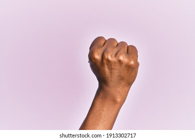 Arm And Hand Of Black Middle Age Woman Over Pink Isolated Background Doing Protest And Revolution Gesture, Fist Expressing Force And Power 