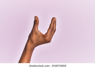 Arm And Hand Of Black Middle Age Woman Over Pink Isolated Background Picking And Taking Invisible Thing, Holding Object With Fingers Showing Space 