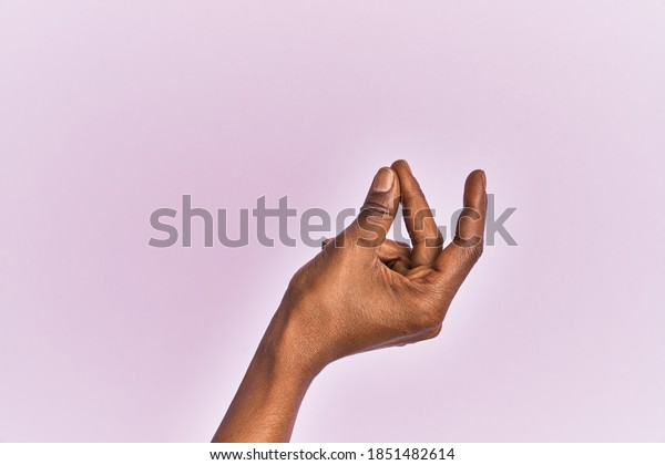 Arm and hand of black middle age woman over pink\
isolated background snapping fingers for success, easy and click\
symbol gesture with hand 