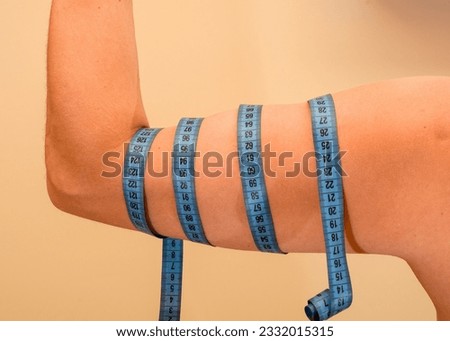 Arm muscles wrapped with measuring tape, tape measure, training plan