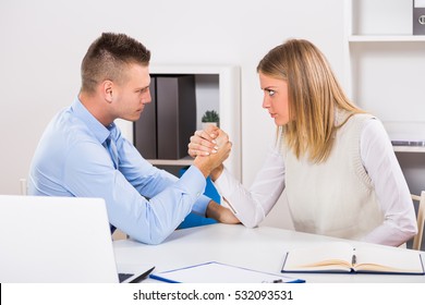 Arm wrestling between businessman and businesswoman at work. Rivalry at work
