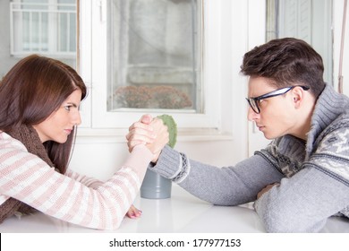 arm wrestling challenge between a young couple at home