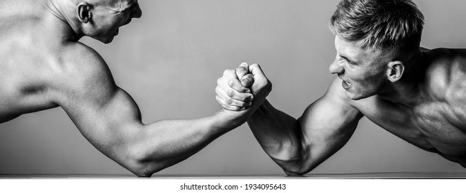 Arm wrestling. Two men arm wrestling. Rivalry, closeup of male arm wrestling. Two hands. Men measuring forces, arms. Hand wrestling, compete. Hands or arms of man. Muscular hand. Black and white.