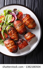 Armadillo Eggs Are A Classic Texas BBQ Staple Served With Salad Close Up On A Plate On The Table. Vertical Top View From Above
