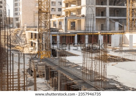 Armature sticking out of building under construction. Process of erection of multi-storey building. Metal armature at construction site. Territory of house under construction. Armature sale concept.