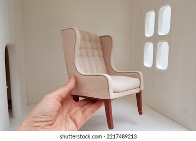 Armchair For A Doll In A Hand Near A Doll House. Miniature And Roombox Hobby.