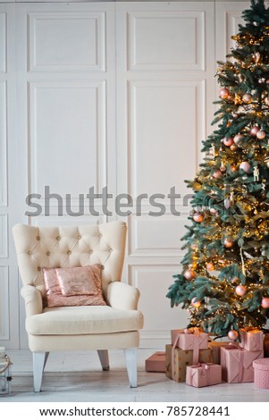 the armchair is near the Christmas tree
