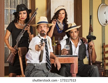 Armed bootlegger in beard with gangsters pointing gun