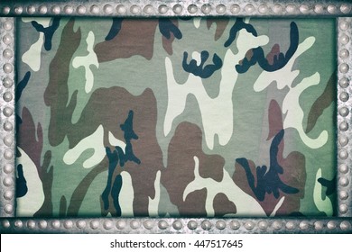 armed force camouflage fabric background with metal rivets frame