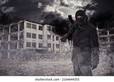 Armed Masked Soldier In Front Of Destroyed Building. Guerrilla Warfare Concept.