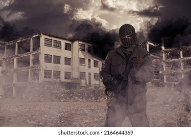 Armed Masked Soldier In Front Of Destroyed Building. Guerrilla Warfare Concept.