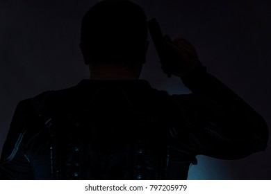 Armed Spy In Bulletproof Vest. It Is Worth A Back To You. In The Hands Holds A Gun.