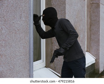 Armed Thief Looking Through Window