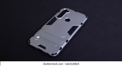 Armor Case For Phone. Strong Plastic Case To Protect Your Phone. Plastic Grey Case On Black Background.