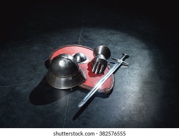 Armor Helmet, Sword And Knight Glove Lie On A Board