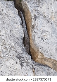 Armored lizard trying to hide in a rock crack. The harshness and cruelty of nature has enchanched into its strong and tough skin.