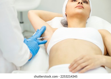 armpit botox procedure in cosmetology clinic, woman patient makes armpit botox injection, hyperhidrosis treatment by cosmetologist doctor, close-up
