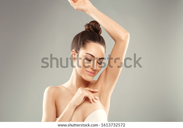 Armpit epilation, lacer hair removal. Young
woman holding her arms up and showing clean underarms, depilation 
smooth clear skin .Beauty
portrait.