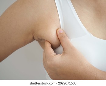 Armpit fat at  asian woman between 30-40 years old dressed in a sporty  bra. closeup photo, blurred.