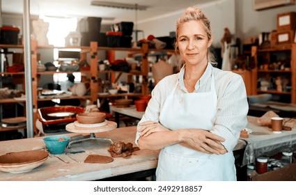 Arms crossed, portrait and woman in pottery studio with clay for design, industry or small business startup. Art, creative and retail with professional person in ceramics workshop for hobby or trade - Powered by Shutterstock