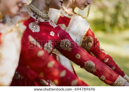 Arms of a dancing Indian women dressed in traditional sari at a park 
