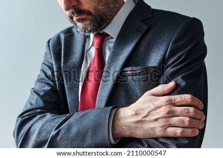 Arms gripping, restrained insecure businessman waiting for bad news, crossed arms posture body language, selective focus
