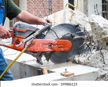Arms holding grinder cutting concrete