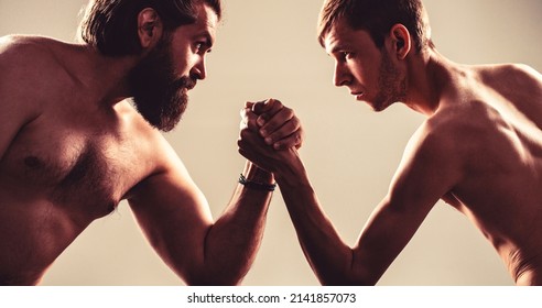 Arms wrestling thin hand, big strong arm in studio. Two man's hands clasped arm wrestling, strong and weak, unequal match. Arm wrestling.