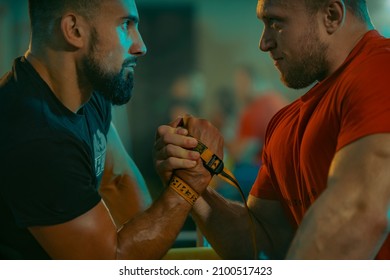 The Armwrestling. Two Strong Athletes In The Gym Compete In Arm Wrestling. Bodybuilders Armwreslers In Athletic Training Room