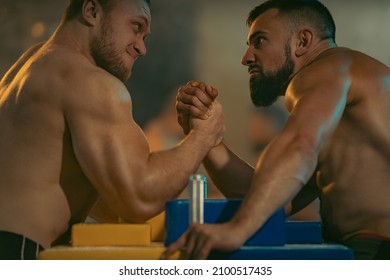 The Armwrestling. Two Strong Athletes In The Gym Compete In Arm Wrestling. Bodybuilders Armwreslers In Athletic Training Room