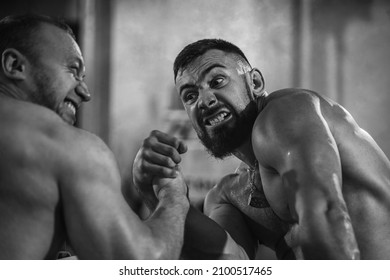 The Armwrestling. Two Strong Athletes In The Gym Compete In Arm Wrestling. Bodybuilders Armwreslers In Athletic Training Room