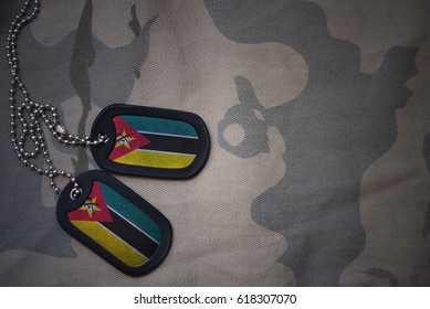 Army Blank, Dog Tag With Flag Of Mozambique On The Khaki Texture Background. Military Concept