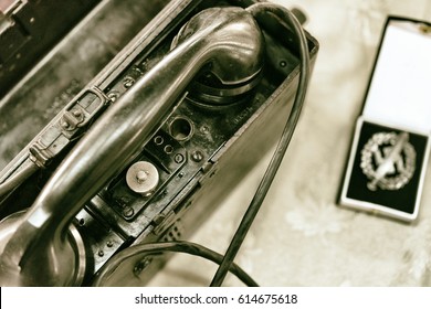 Army Field Telephone Next To A German Army Medal, Vintage