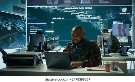 Army intelligence expert utilizes modern computer systems and satellite radar imagery to enhance national security, strategic initiatives and ensure defense in mission control center. Camera B. - Powered by Shutterstock