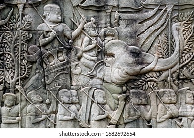 Army With Khmer Soldiers And Elephants On The 12th Century Relief Of Bayon Temple, Cambodia. Historical Artwork On Wall Of The Landmark In Angkor. UNESCO World Heritage Site.