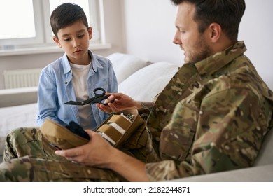 Army Man Explaining The Usage Of Medical Shears To Kid