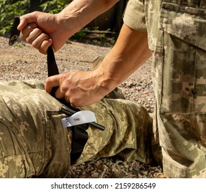 Army Medics Practice Applying A Tourniquet To The Leg Of A Wounded Soldier. Combat Tactical Equipment. Combat Use Turnstile. The Concept Of Military Medicine.