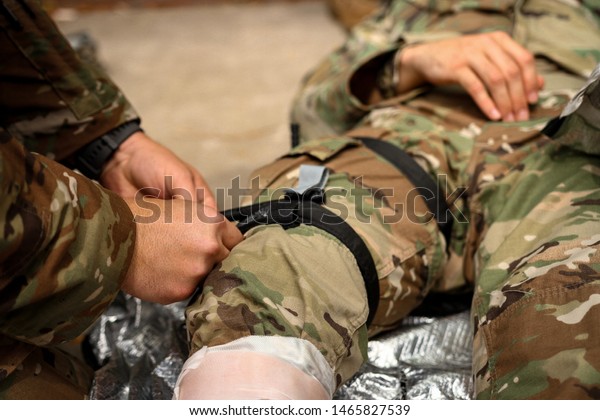 Army medics\
practicing tourniquet\
application