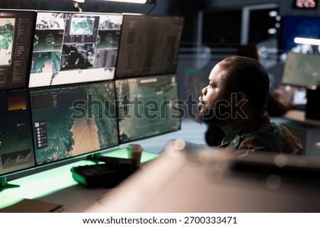 Army operative in command center analyzing surveillance data during global warfare. Intelligence agent in base of operations completes mission during World War 3 geopolitical operation
