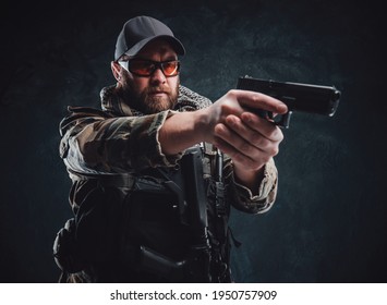 Army Soldier With A Cap And Glasses Aiming A Handgun In Dark Background