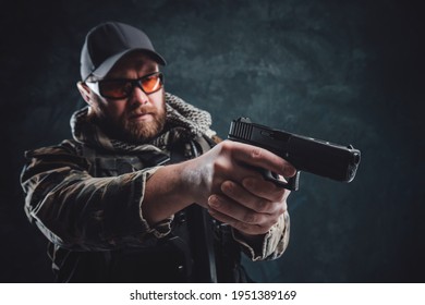 Army Soldier With A Cap And Glasses Aiming A Handgun In Dark Background