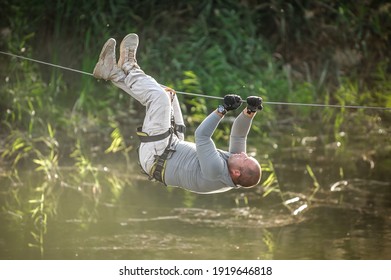 Army soldier conducts the rope bridge water crossing exercise. Water survival training - Powered by Shutterstock