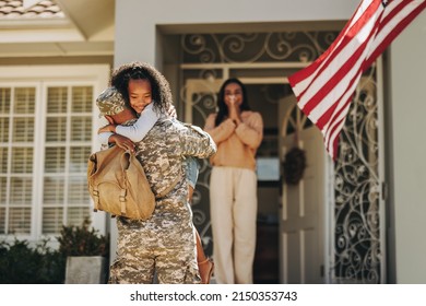 Army soldier embracing his daughter after coming back home. American serviceman surprising his wife and daughter with his return. Military man reuniting with his family after deployment. - Powered by Shutterstock