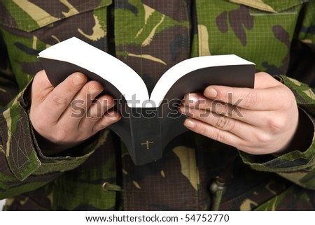 Army soldier reading bible ,selective focus on book and hands