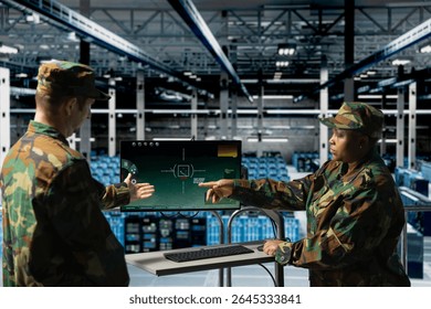 Army soldiers in data center using digital crosshairs to lock onto enemy targets. Military units in server hub command room looking at tactical software screen on monitor