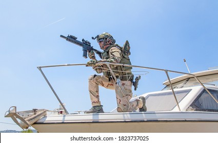 Army Special Forces Soldier, Commando Fighter In Full Ammunition, Wearing Body Armor And Helmet, Armed Service Rifle, Standing On Bow Of Speed Boat, Looking Into Distance During Seacoast Patrolling