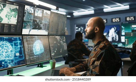 Army specialist employing AI tech to improve military warfare systems and threat monitoring. IT admin uses neural networks to enhance combat operational capabilities, camera B - Powered by Shutterstock